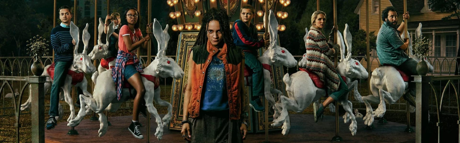 A girl stands in front of a carousel with people riding rabbits